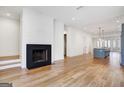 Bright living room with a modern fireplace and hardwood flooring, open to kitchen at 434 Selborne Way, Chattahoochee Hills, GA 30268
