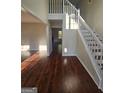 Spacious foyer featuring gleaming hardwood floors, a staircase with white railings, and natural light at 1857 Oak Hill Springs Blvd, Lithonia, GA 30058