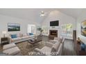 Staged living room featuring a vaulted ceiling, brick fireplace, and hardwood flooring at 249 Edenwylde Ct, Hampton, GA 30228