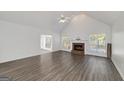 Bright living room boasts vaulted ceilings, brick fireplace, large windows, and modern wood-look floors at 249 Edenwylde Ct, Hampton, GA 30228