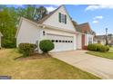 A side exterior view of the home showcasing the driveway, lawn and one-car garage at 161 Spring Creek Blvd, Mcdonough, GA 30253