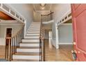 Grand foyer with hardwood floors, a staircase with wrought iron railings, and an open floor plan at 10460 Cranchester Way, Alpharetta, GA 30022