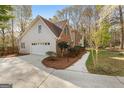 Exterior view of home with attached garage, mature landscaping, and driveway at 110 Windsor Hts, Fayetteville, GA 30215