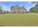 Two-story brick home on a grassy lot beneath a partly cloudy sky at 198 Crestwood Rd, Tyrone, GA 30290