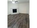 Open-concept living room featuring a brick fireplace and wood-look flooring at 1172 Sheffield Ct, Jonesboro, GA 30238
