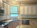 Traditional style kitchen boasts granite countertops, stainless steel appliances, and bright, windowed workspace at 9340 Basswood Way, Jonesboro, GA 30236