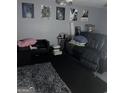 Basement media room space with black leather seating, movie posters, and dark carpet at 9340 Baswood Way, Jonesboro, GA 30236