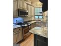 Kitchen featuring stainless steel appliances, tile backsplash, granite counters, and wood cabinets at 9340 Baswood Way, Jonesboro, GA 30236