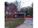 Brick home exterior featuring a vibrant tree, well-manicured lawn, and concrete driveway at 1217 Dove Ct, Morrow, GA 30260