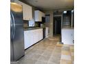 Spacious kitchen featuring white cabinets, tile flooring, and stainless steel refrigerator at 1217 Dove Ct, Morrow, GA 30260