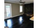 Cozy living room with dark wood floors, a stone fireplace, and access to the yard at 1217 Dove Ct, Morrow, GA 30260
