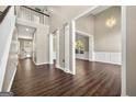 Open-concept living room with hardwood floors, wainscoting, and elegant chandelier lighting at 119 Brookgrove Ln, Peachtree City, GA 30269