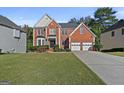 Charming two-story brick home with manicured lawn and attached two-car garage at 1721 Telfair Chase Way, Lawrenceville, GA 30043