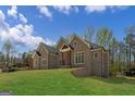 Elegant brick home featuring an expansive green lawn on a sloped lot at 5265 Brookhollow Dr, Douglasville, GA 30135