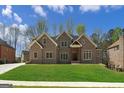 Stunning brick home displays a well-manicured lawn, with its inviting façade under a blue sky at 5265 Brookhollow Dr, Douglasville, GA 30135