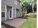 View of a backyard featuring a concrete patio and a well-maintained lawn with garden beds at 5860 Fairway View Dr, Suwanee, GA 30024