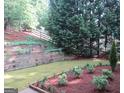 Landscaped backyard featuring a tiered garden bed and a wooden fence at 5860 Fairway View Dr, Suwanee, GA 30024