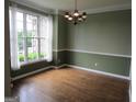Traditional dining room with hardwood floors, large windows, and a classic chandelier at 5860 Fairway View Dr, Suwanee, GA 30024