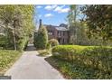 Long driveway leading to a brick home surrounded by manicured bushes and mature trees at 619 E Pelham Ne Rd, Atlanta, GA 30324
