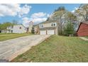 Two-story home with two-car garage and mature landscaping viewed from the side yard at 909 Chapman Cir, Stone Mountain, GA 30088