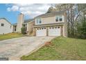 Two-story home with two-car garage and mature landscaping viewed from the side yard at 909 Chapman Cir, Stone Mountain, GA 30088