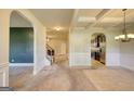 Spacious living room with arched doorways and view of staircase and modern kitchen at 117 Berkeley Way, Hampton, GA 30228