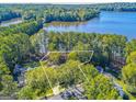 Aerial view of a lakefront property showcasing the home's location amidst lush greenery and a serene lake at 504 Telfair Park, Peachtree City, GA 30269