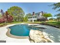 Backyard oasis featuring a large swimming pool, spa, and lush landscaping at 935 Amelia Rd, Locust Grove, GA 30248