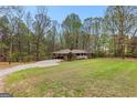 A brick ranch-style home features a porte-cochere and a large, grassy front yard at 1407 Highway 92 N, Fayetteville, GA 30214