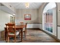 Formal dining room featuring a large window, classic chandelier, and wood floors, perfect for Gathering gatherings at 205 Wynnfield Way, Mcdonough, GA 30252