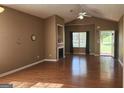 Spacious living room showcasing a fireplace, wood floors, and access to the outdoors at 128 Astilbe Meadow Dr, Locust Grove, GA 30248