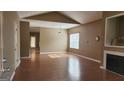 Bright living room featuring hardwood floors, vaulted ceilings, and a cozy fireplace at 128 Astilbe Meadow Dr, Locust Grove, GA 30248