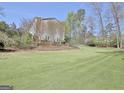 Vast backyard featuring a lush green lawn and mature trees providing ample privacy at 100 Smokerise Trce, Peachtree City, GA 30269