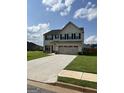 Beautiful two-story house with a long concrete driveway and manicured lawn at 517 Daffodil Ln, Mcdonough, GA 30253