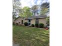 Charming one-story home with brick exterior, arched windows and a green lawn at 2884 Haddon Dr, Rex, GA 30273