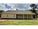 Spacious backyard featuring a covered porch, level lawn, and mature trees at 4529 Jersey Covington Rd, Covington, GA 30014