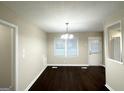 Bright dining room with dark wood flooring, a chandelier, and large windows offering natural light at 4250 Timber Valley Ct, Decatur, GA 30032