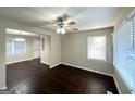 A bright living room with dark hardwood floors, a ceiling fan, and large windows that let in natural light at 4250 Timber Valley Ct, Decatur, GA 30032