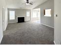 Spacious living room with fireplace, neutral paint, large windows and a ceiling fan at 210 Huntington Dr, Mcdonough, GA 30253