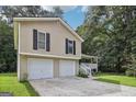 Attractive exterior showcasing a two-story home with a two-car garage and manicured lawn at 3980 Carlton Cove Ct, Loganville, GA 30052