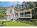 Inviting home with a two-car garage, white porch and lush green lawn and landscaping at 3980 Carlton Cove Ct, Loganville, GA 30052