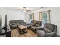 Comfortable living room featuring plush sofas, wood floors, and natural light at 3980 Carlton Cove Ct, Loganville, GA 30052
