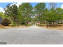 View of the home from the street, showcasing the long driveway and mature trees at 368 Yellowwood Dr, Sharpsburg, GA 30277