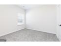 Bright bedroom features neutral carpeting, a large window, and white walls at 3363 Arabian Farm Ln, Dacula, GA 30019