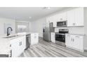 Modern kitchen featuring stainless steel appliances, white cabinets, and a granite island at 3363 Arabian Farm Ln, Dacula, GA 30019