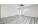 Bright, open living room featuring gray vinyl floors and a ceiling fan at 3372 Arabian Farm Ln, Dacula, GA 30019