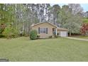 Attractive home surrounded by mature trees and green grass at 212 Bella Rosa, Peachtree City, GA 30269