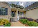 Inviting covered front porch with decorative columns and well-kept landscaping at 116 Laurel Ln, Social Circle, GA 30025