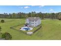 Expansive backyard featuring a fenced pool area, patio, fire pit, and lush green space at 176 Butler Rd, Brooks, GA 30205