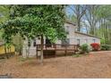 Beautifully situated two-story home with a large wooden deck, nestled amongst mature trees, offering a serene atmosphere at 5296 Golfcrest Cir, Stone Mountain, GA 30088